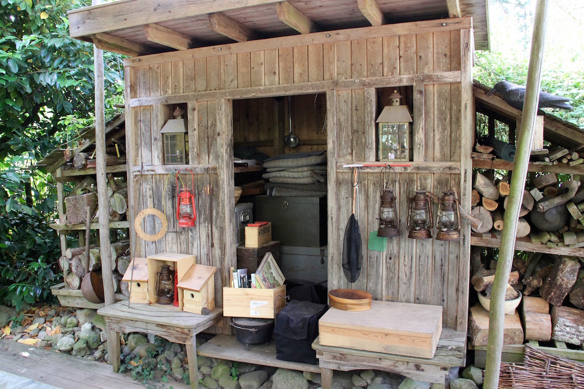 Holzhaus mit vielen Details wie Lampen, Vogelhäuschen, Holzvorräten